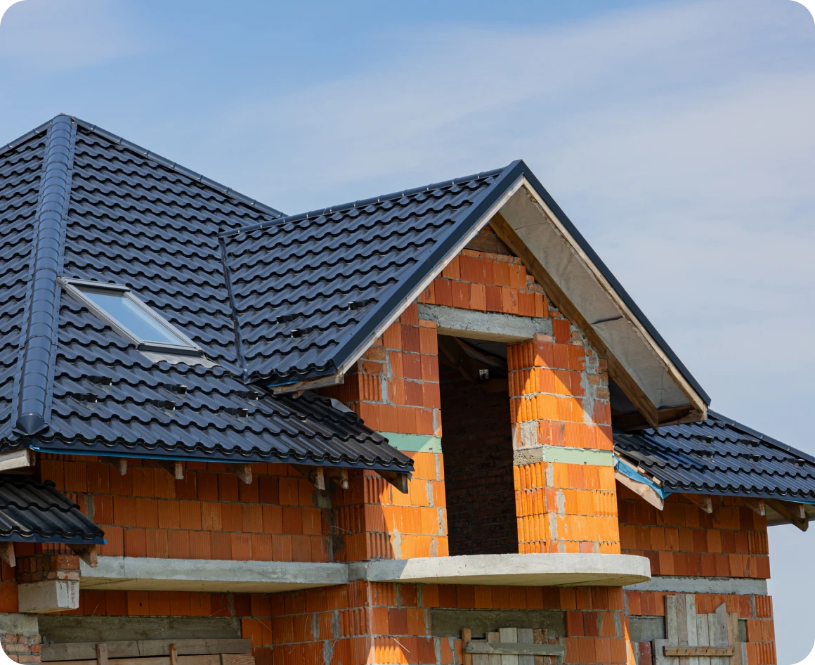 Unfinished brick house with dark roof