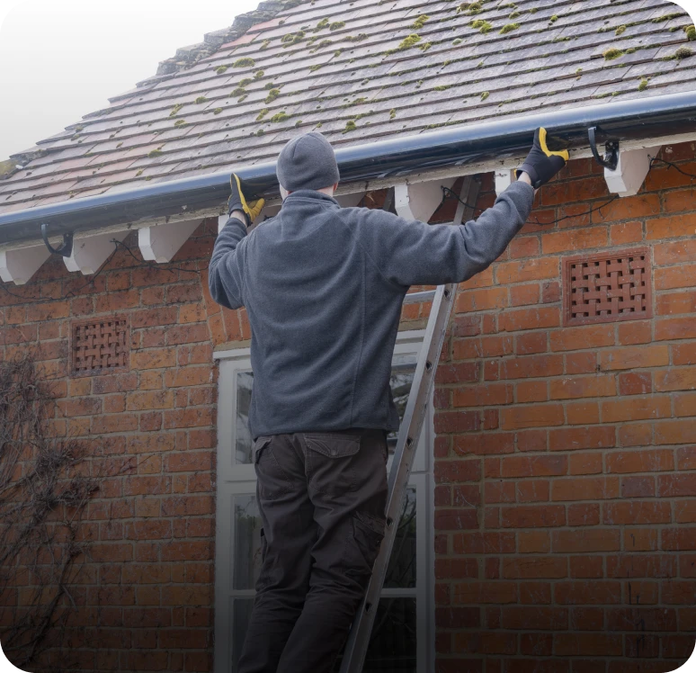 Man fixing roof guttering.