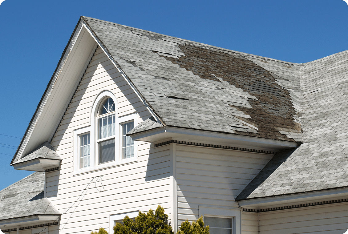 House with peeling roof shingles