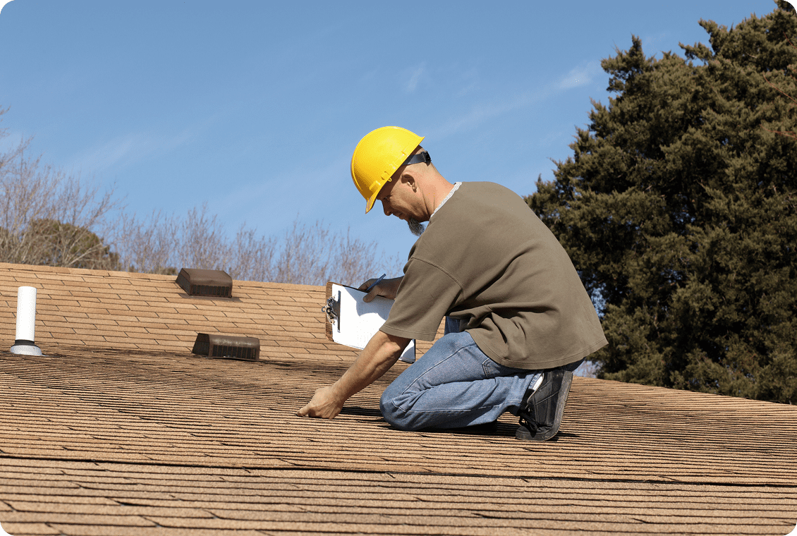 Person inspecting roof with yellow hard hat.