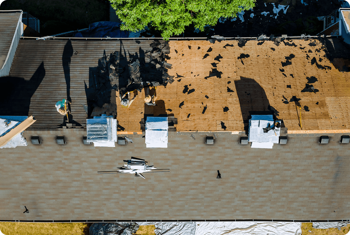 Roofers repairing shingles on a house