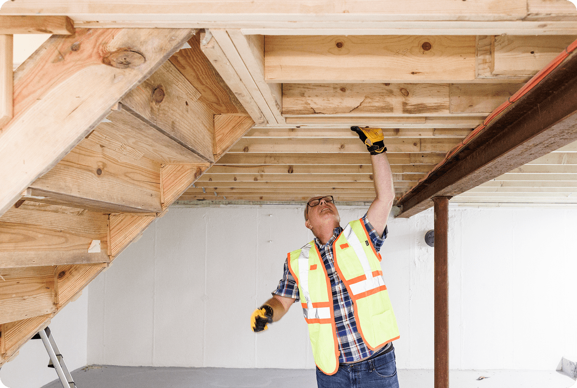 Man in safety vest inspecting ceiling